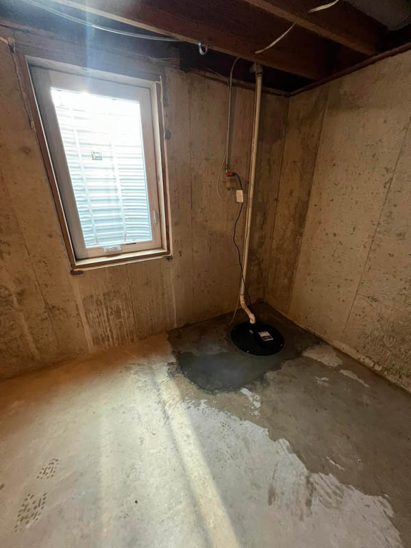 new sump pump installed in basement next to an egress window in springfield illinois